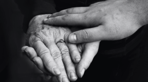 holding elderly hand black and white