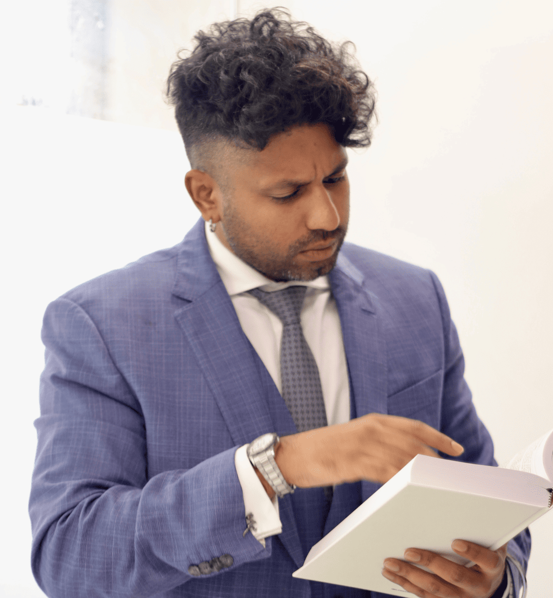 a litigation lawyer in a suit reading a book in a white room